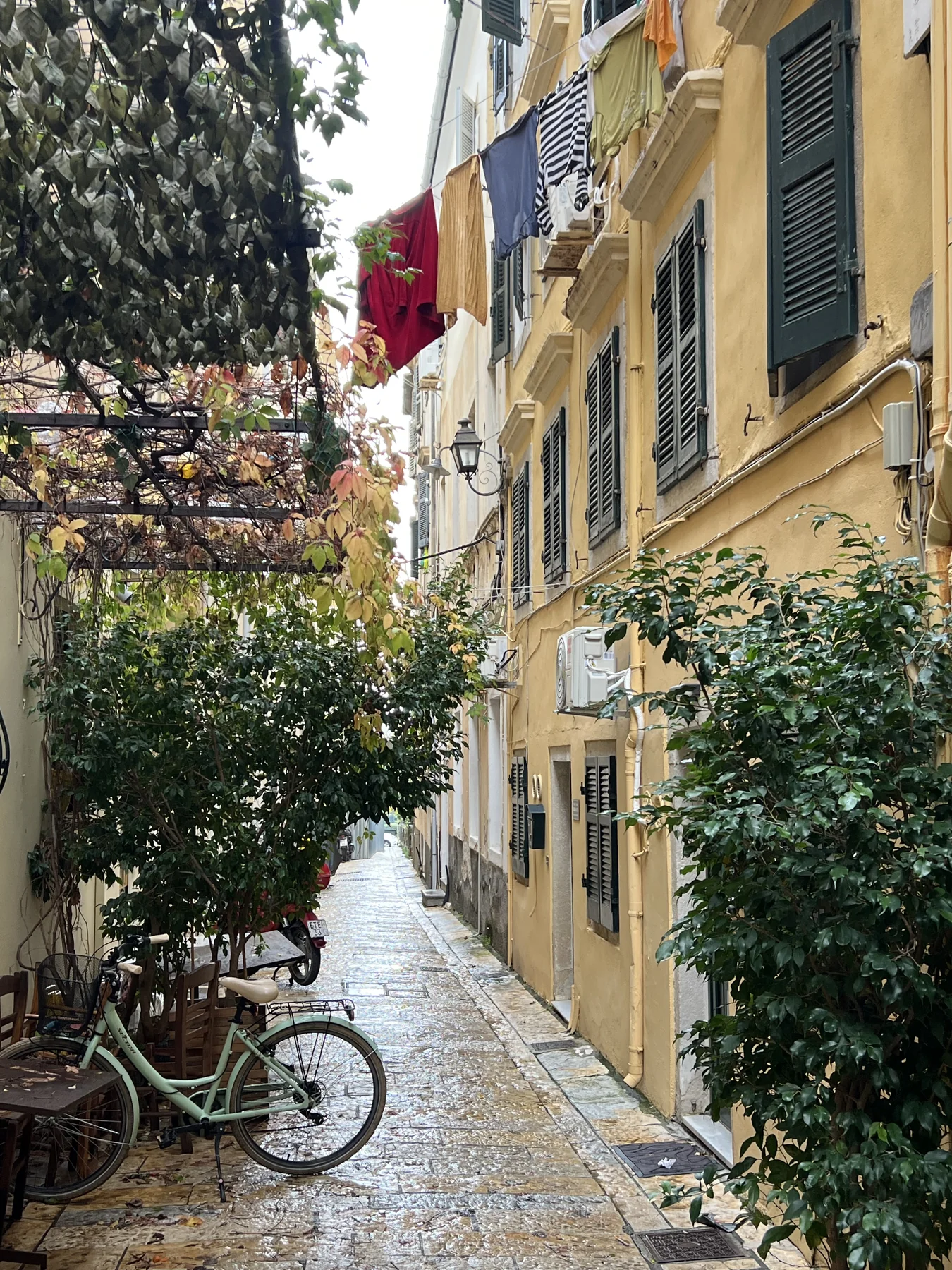 Venetian alley with bicycle, laundry overhead, yellow buildings