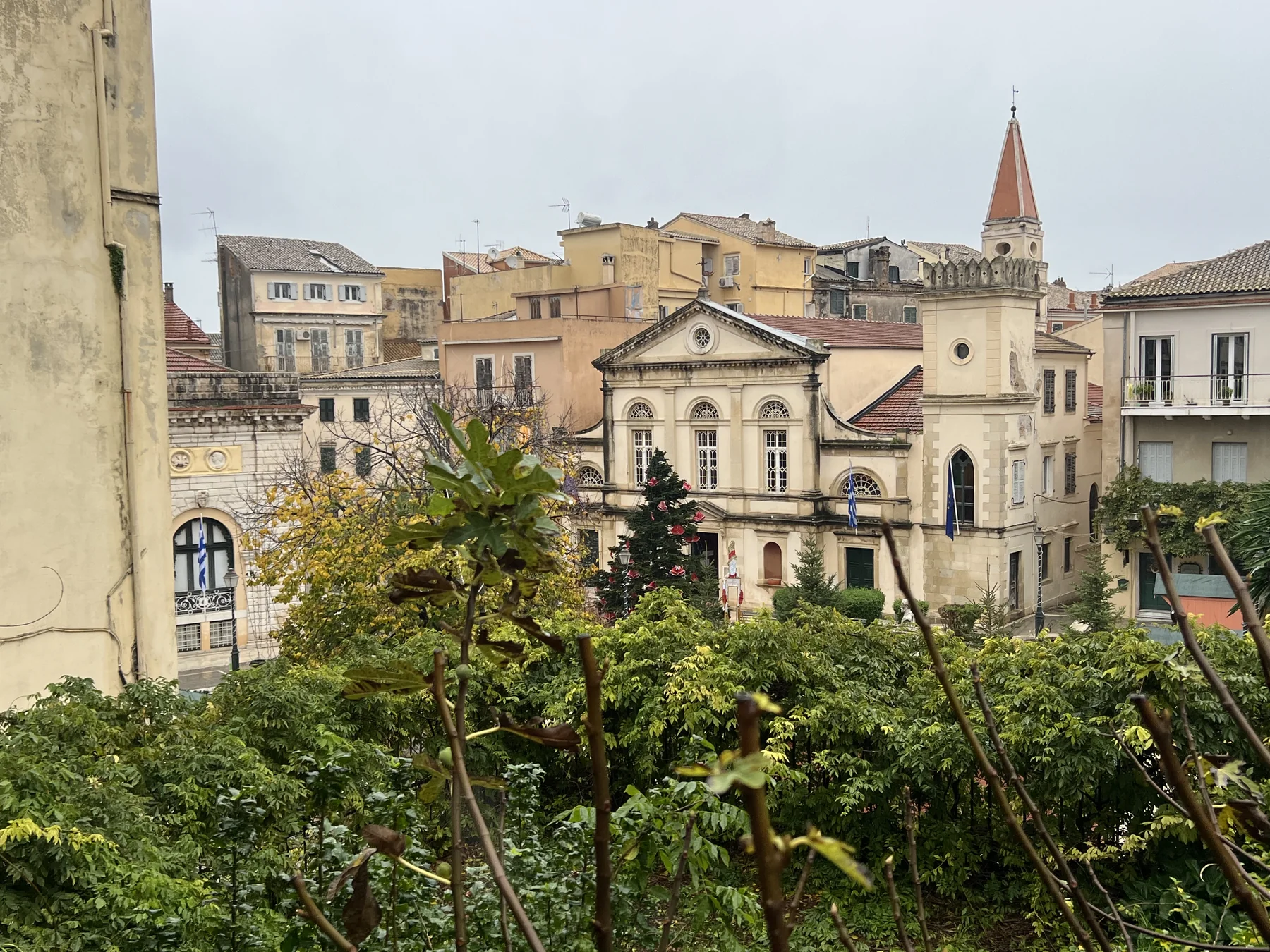 Corfu Old Town rooftops in rain, church spire, grey winter sky