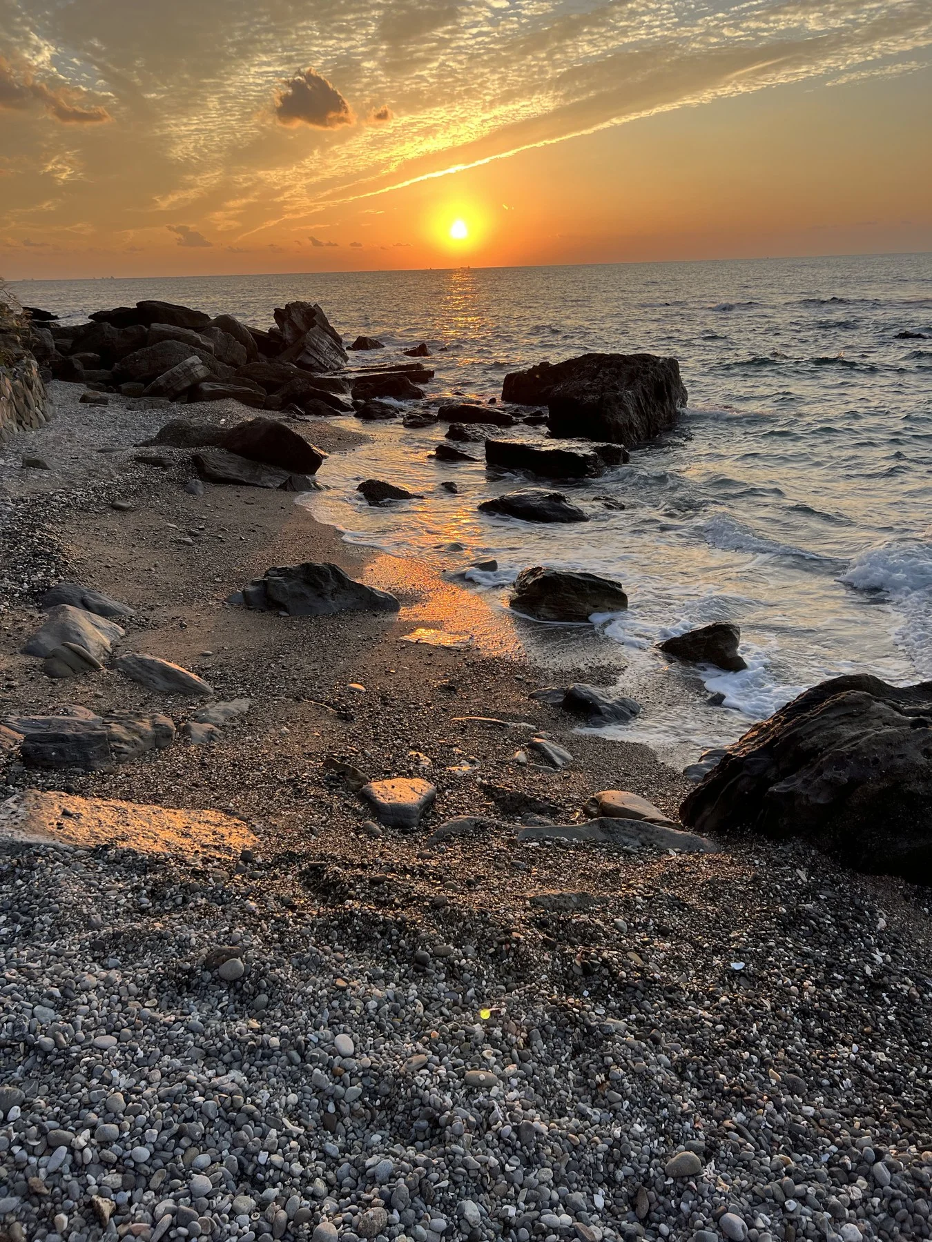 Sunset on rocky pebble shore, Pacific coast
